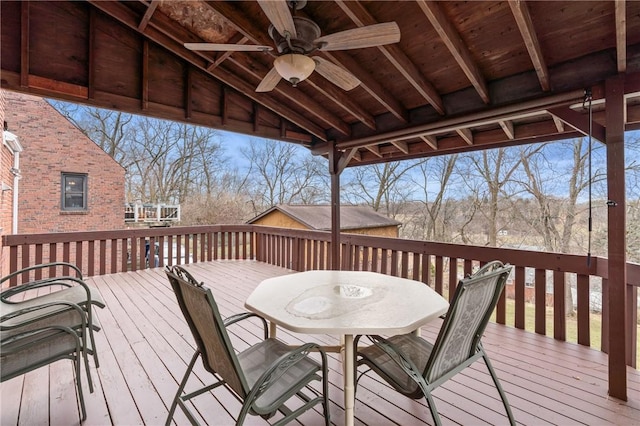 wooden terrace with ceiling fan and outdoor dining area