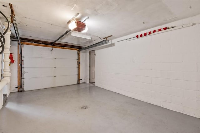 garage with concrete block wall and a garage door opener