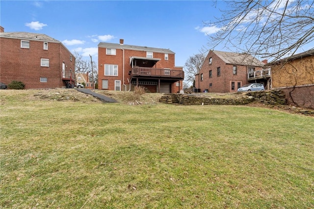 rear view of property featuring a yard, brick siding, a chimney, and a wooden deck