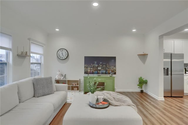 living room featuring light wood-style flooring, baseboards, and recessed lighting