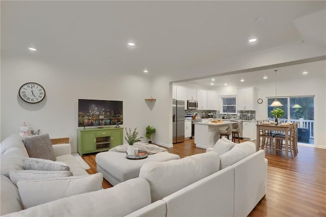 living room with light wood-style floors and recessed lighting