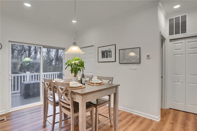 dining area with light wood-style floors, visible vents, and baseboards