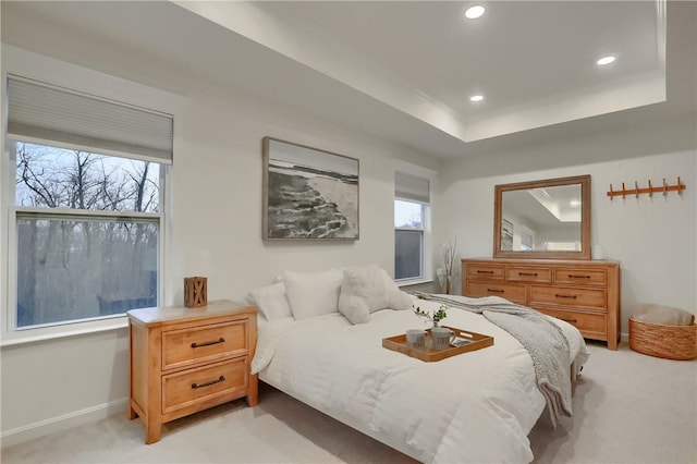 bedroom featuring recessed lighting, a raised ceiling, multiple windows, and light carpet