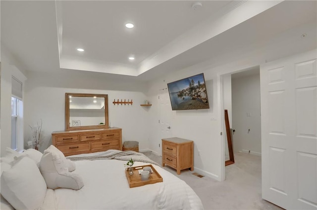 bedroom with light carpet, a tray ceiling, baseboards, and recessed lighting