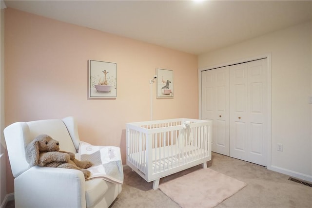 bedroom with light colored carpet, a closet, visible vents, and baseboards