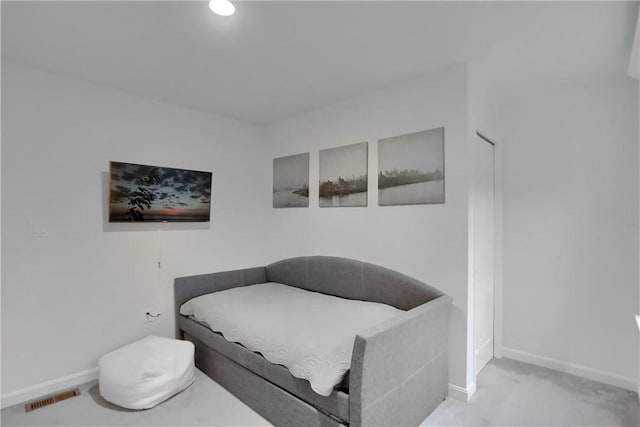 bedroom with baseboards, visible vents, and light colored carpet