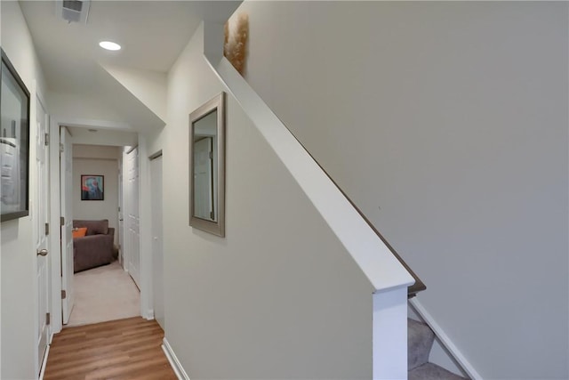 corridor featuring baseboards, recessed lighting, and light wood-style floors