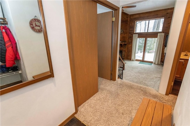 hall featuring carpet floors and wood walls