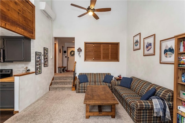 living area featuring a towering ceiling, ceiling fan, dark colored carpet, and a wall mounted air conditioner