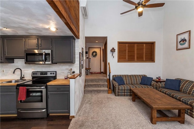 kitchen with decorative backsplash, appliances with stainless steel finishes, light countertops, gray cabinetry, and a sink