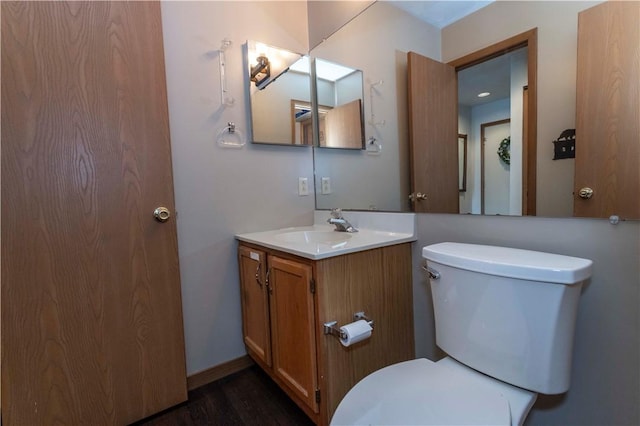 bathroom with vanity, toilet, and wood finished floors