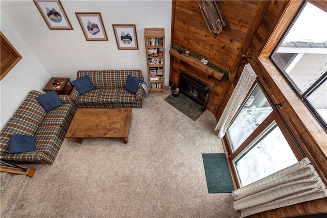 living room featuring a fireplace with flush hearth, carpet, and vaulted ceiling