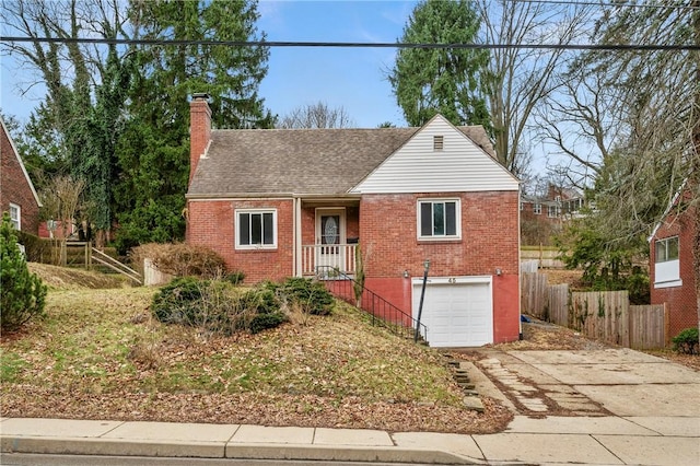 view of front of house with brick siding, fence, a chimney, and an attached garage