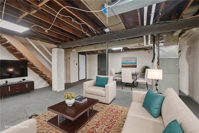 living area featuring stairs and concrete flooring