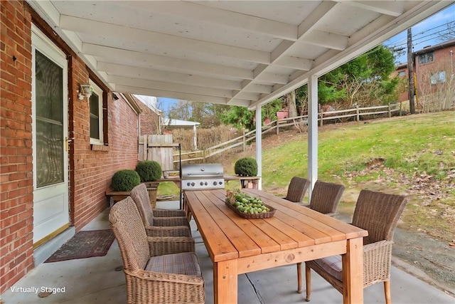 view of patio with outdoor dining area, grilling area, and fence