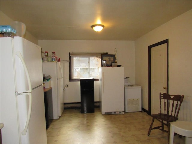 kitchen featuring washer / clothes dryer and freestanding refrigerator