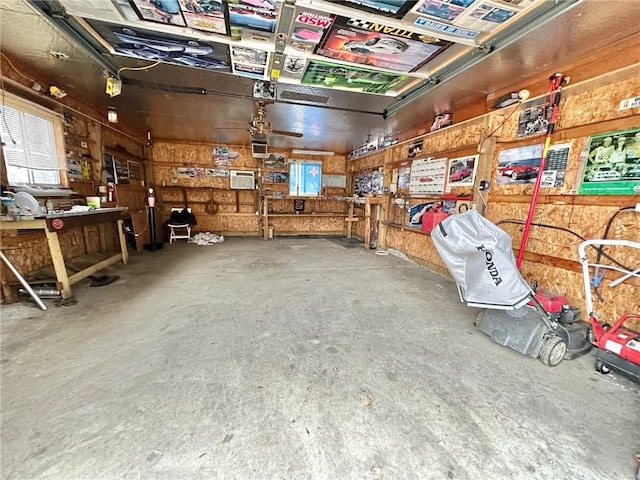 miscellaneous room with a workshop area, a garage, and concrete floors