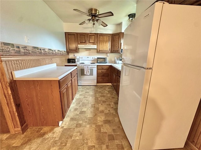kitchen featuring a ceiling fan, white appliances, under cabinet range hood, and brown cabinetry
