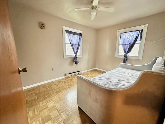 bedroom with a baseboard heating unit, ceiling fan, and baseboards