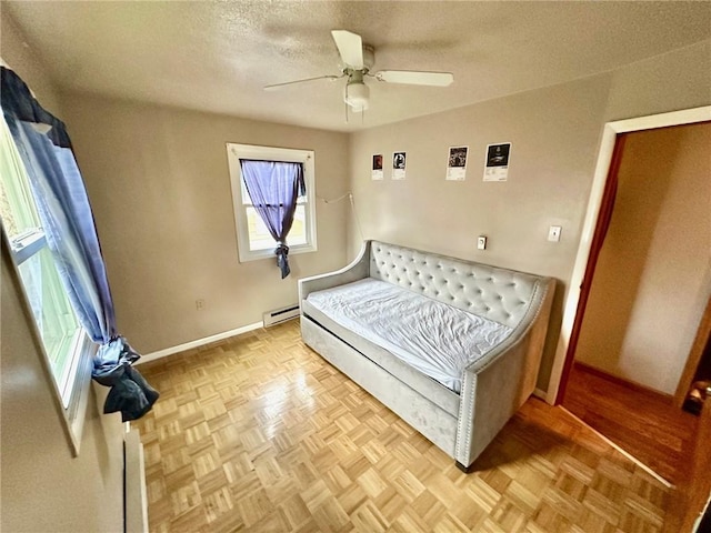 bedroom with a baseboard radiator, a ceiling fan, a textured ceiling, and baseboards