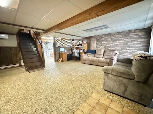 living area with a wall unit AC, stairs, a baseboard radiator, and a drop ceiling
