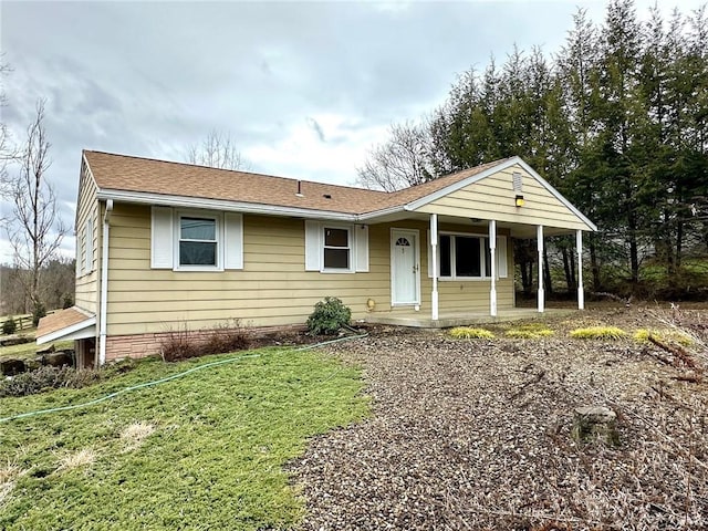 view of front of house featuring covered porch, roof with shingles, and a front lawn