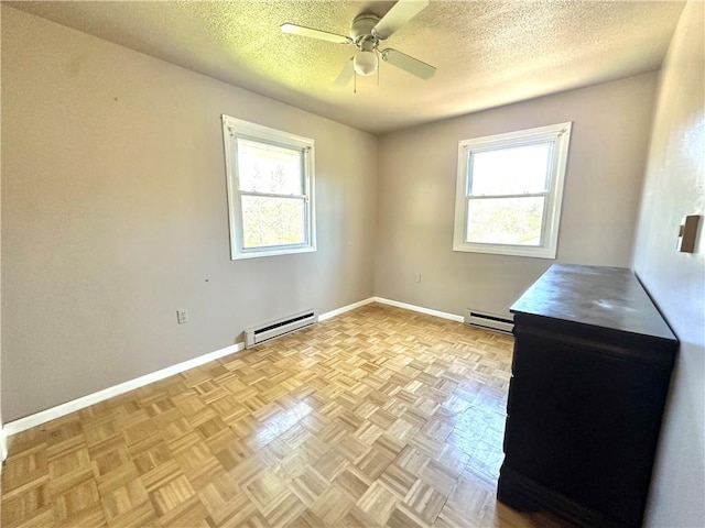 empty room with a textured ceiling, ceiling fan, baseboards, and a baseboard radiator