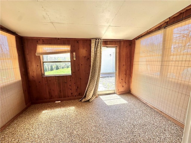 spare room featuring a wealth of natural light and wooden walls