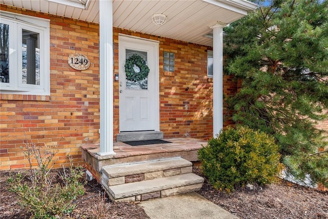 doorway to property featuring brick siding