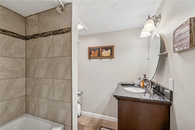 bathroom featuring washtub / shower combination, baseboards, and vanity