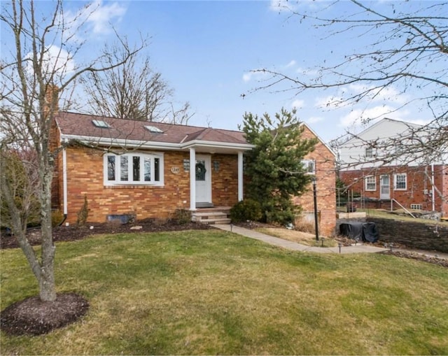 view of front of house with brick siding, a front lawn, and a chimney