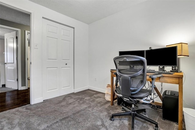 office space with dark carpet, a textured ceiling, and baseboards