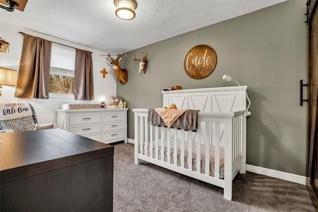 bedroom featuring a textured ceiling, dark colored carpet, a nursery area, and baseboards