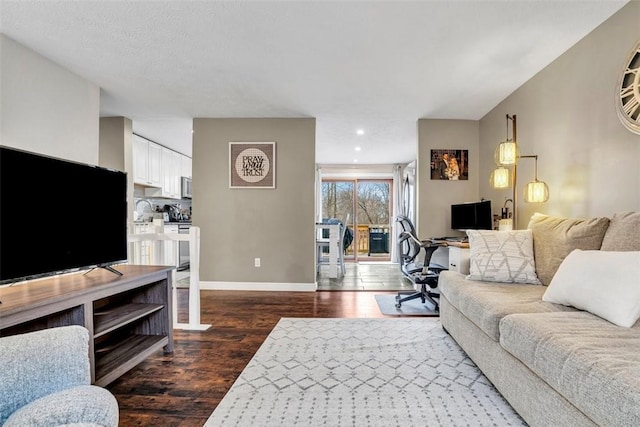 living area featuring recessed lighting, dark wood finished floors, and baseboards