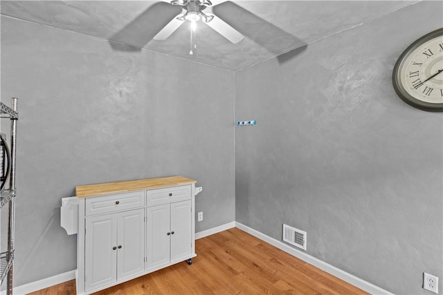 interior space featuring light wood-type flooring, baseboards, visible vents, and ceiling fan
