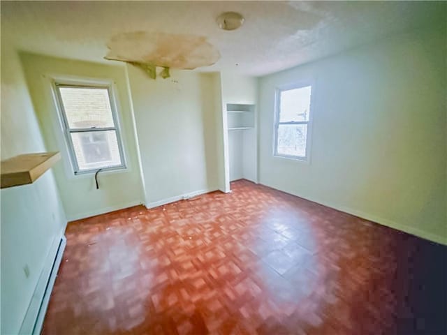 unfurnished bedroom with a baseboard radiator and baseboards