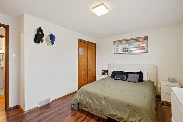 bedroom featuring a closet, visible vents, baseboards, and wood finished floors