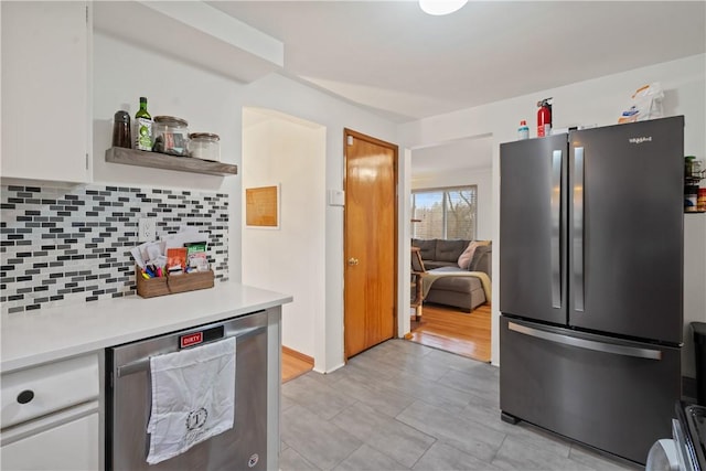 kitchen featuring appliances with stainless steel finishes, tasteful backsplash, light countertops, and white cabinetry