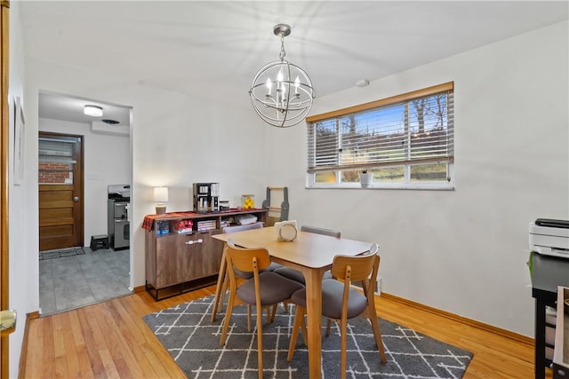 dining area featuring a notable chandelier, baseboards, and wood finished floors