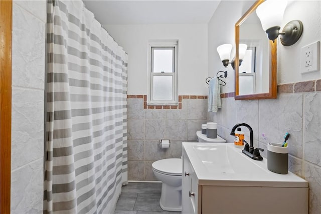 bathroom featuring tile walls, curtained shower, toilet, vanity, and tile patterned floors