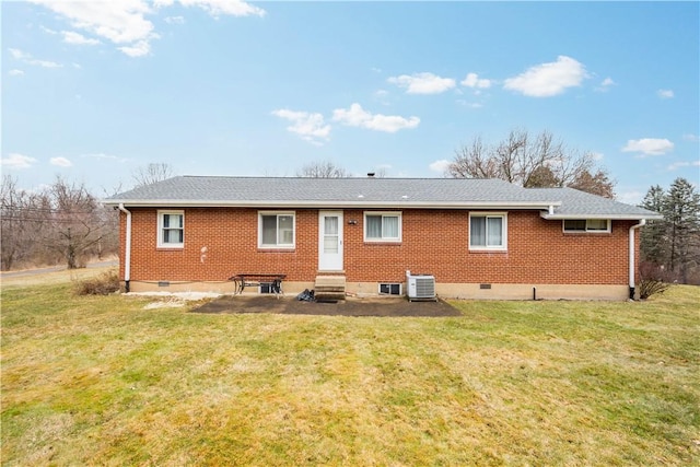 back of property featuring entry steps, crawl space, a yard, central AC, and brick siding