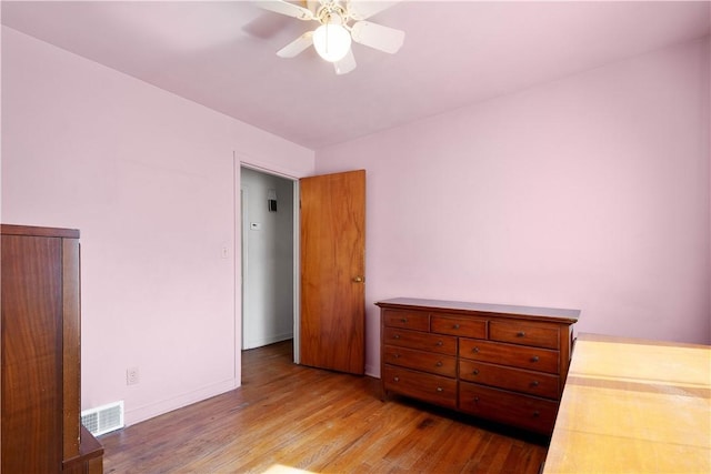 bedroom with visible vents, ceiling fan, baseboards, and wood finished floors