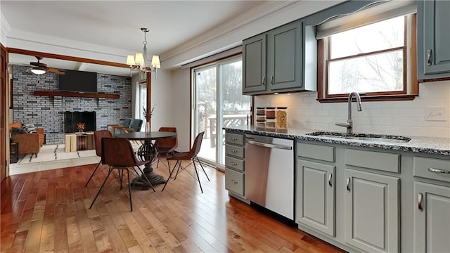 kitchen featuring gray cabinetry, a sink, light wood-style floors, decorative backsplash, and dishwasher