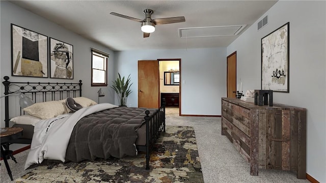 bedroom featuring light carpet, attic access, visible vents, baseboards, and ensuite bath