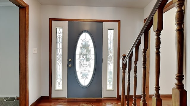 foyer entrance featuring stairs, wood finished floors, and visible vents