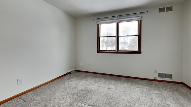 unfurnished room featuring carpet flooring, visible vents, and baseboards