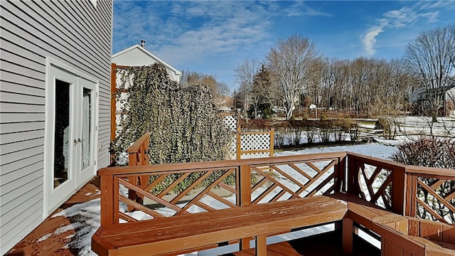 snow covered deck with french doors