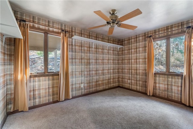 spare room with baseboards, carpet floors, ceiling fan, and wallpapered walls