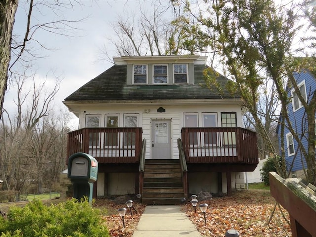 bungalow-style home with a deck and stairs