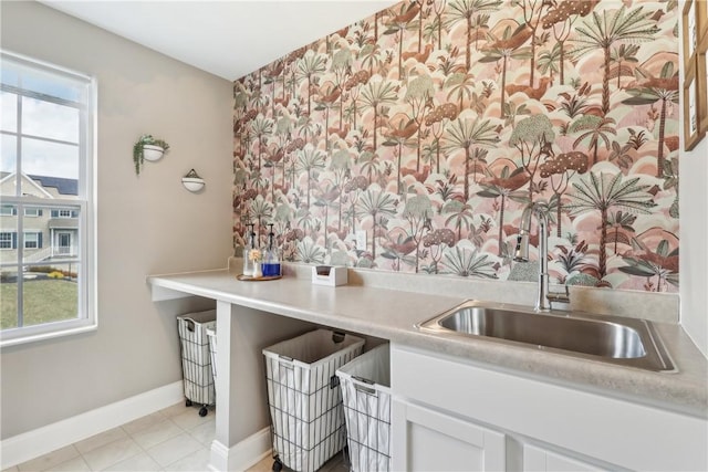 kitchen with light countertops, white cabinetry, a wealth of natural light, and baseboards